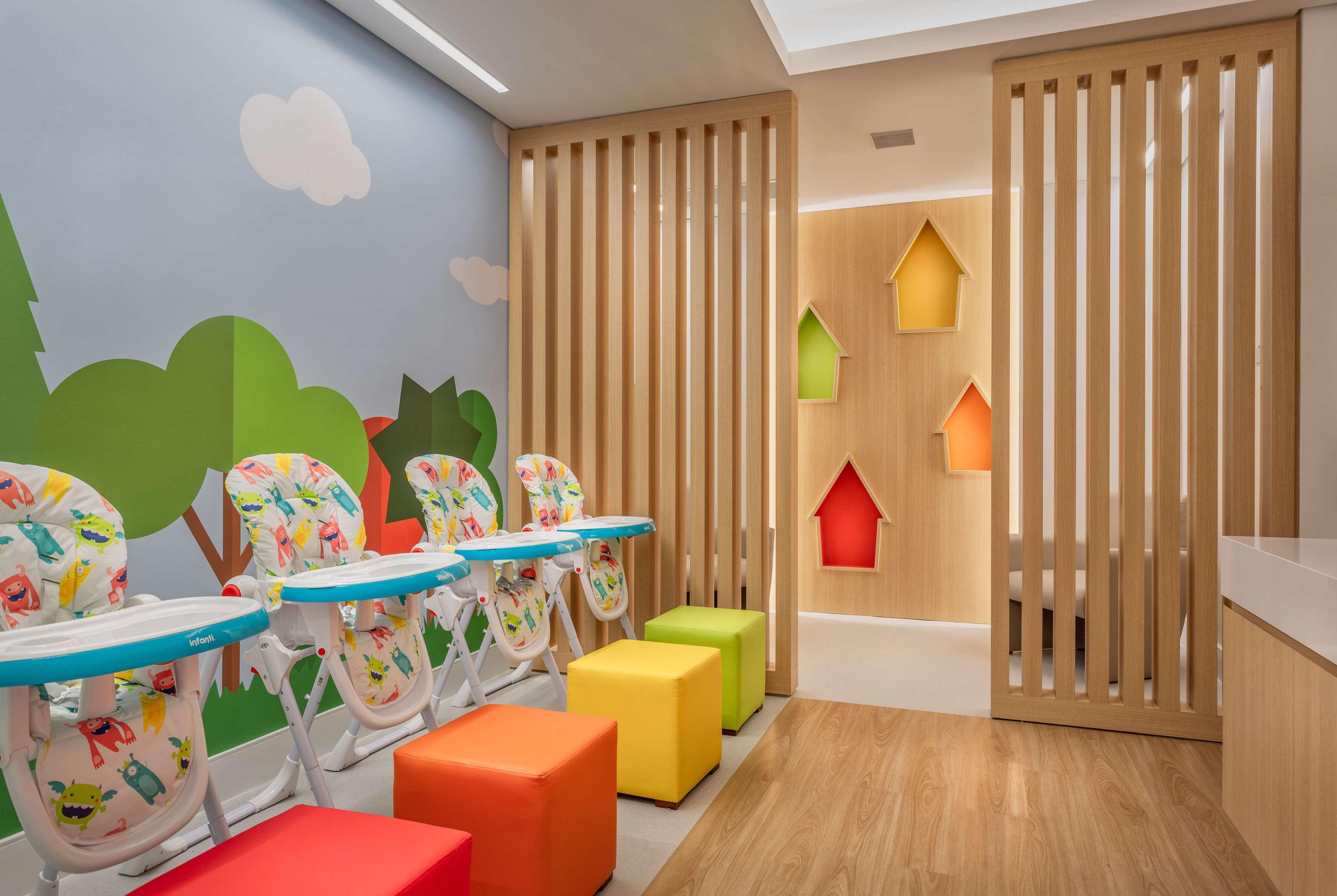 Wyndham Gramado Termas Resort & Spa Exterior foto The photo shows a brightly colored, child-friendly room designed for young children. On one side, there are several high chairs with playful designs, indicating it's a space for feeding or play. The walls are decorated with cheerful illustrations of 