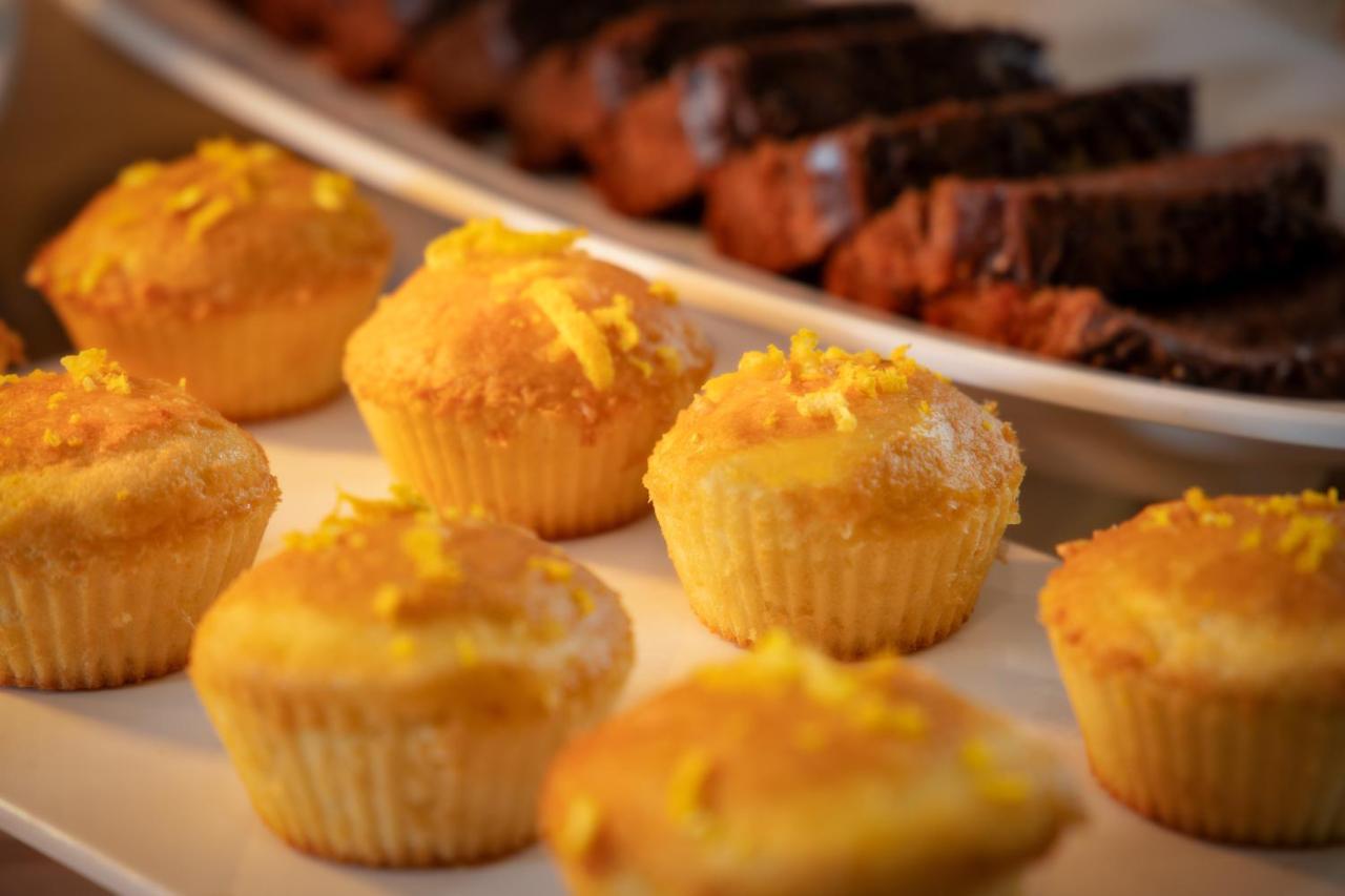 Wyndham Gramado Termas Resort & Spa Exterior foto The image features a platter of baked goods, prominently displaying a row of light yellow cupcakes decorated with what appears to be a sprinkle of yellow zest on top. In the background, there are slices of darker baked goods, likely chocolate bread o